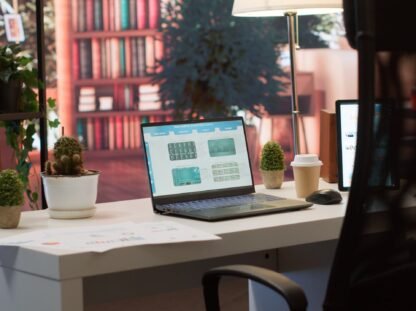 Empty home office setup showing documents and financial reports on laptop Responsive Web Design Dubai